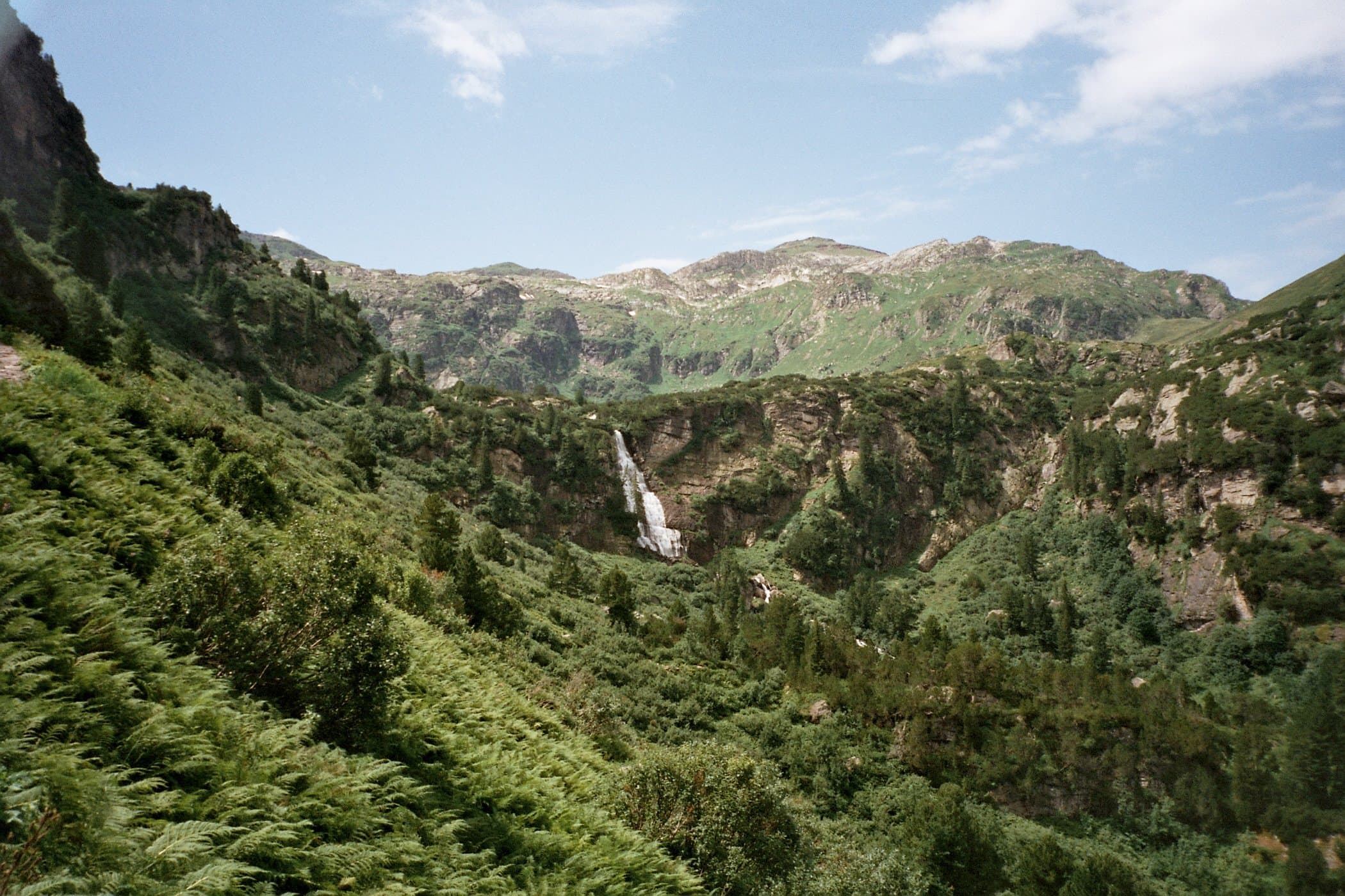 Waterfall in a green alpine valley, Swiss Alps, Switzerland